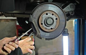 Person fixing brake pads on a car